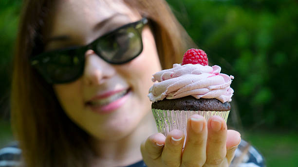 istock Smiling girl holds a cupcake 527038114