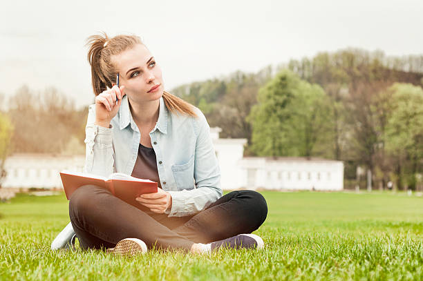 istock Pensive serious woman sitting outside and writing in her diary 527040786