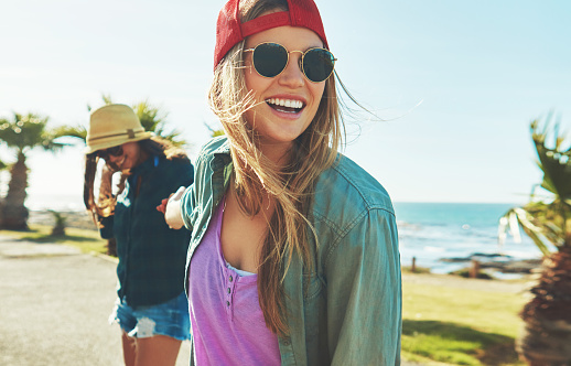 Shot of two friends hanging out on the boardwalk