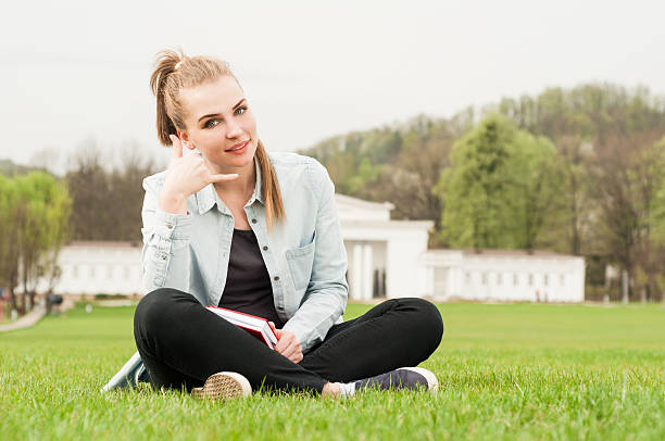 istock Relaxed young hipster making a call me sign and smiling 527043194