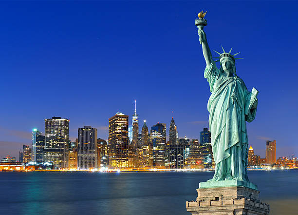 manhattan por la noche y la estatua de la libertad. - statue of liberty new york city statue usa fotografías e imágenes de stock