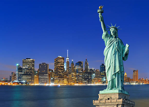 Manhattan à noite e da Estátua da Liberdade. - fotografia de stock