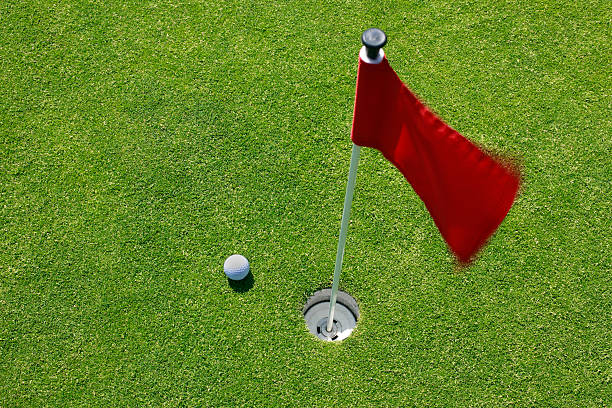 istock Golf ball on green with red flag. 527044476