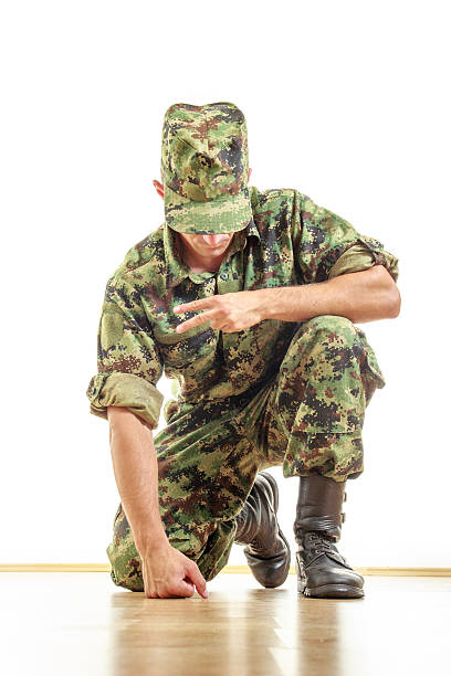 istock soldier in camouflage uniform and hat kneeling on the floor 527048457