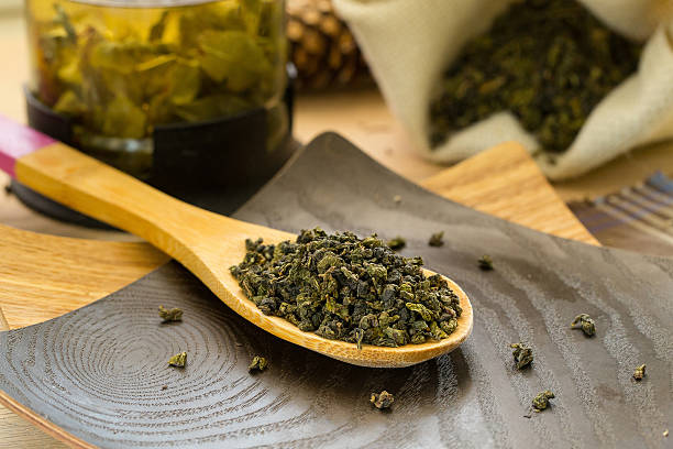 istock Dry Oolong tea on a wooden spoon 527049110