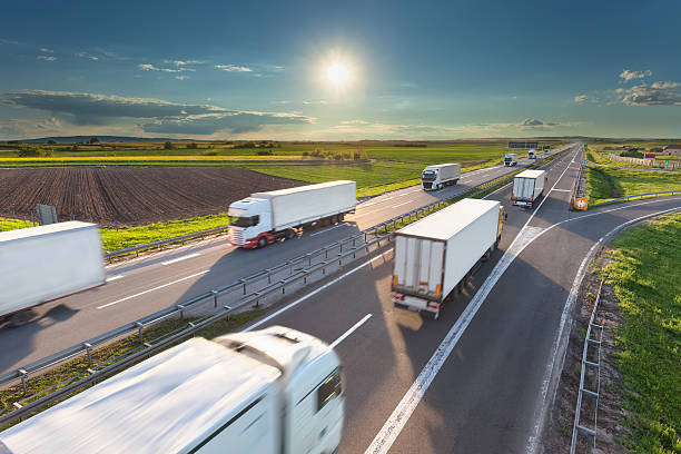 istock Big white trucks on highway at idyllic sunny morning 527049122