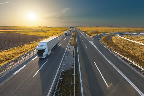 istock Big white trucks on the empty highway at sunset 527049438