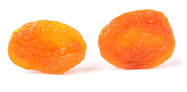 istock two dried apricots on a white background closeup 527049454
