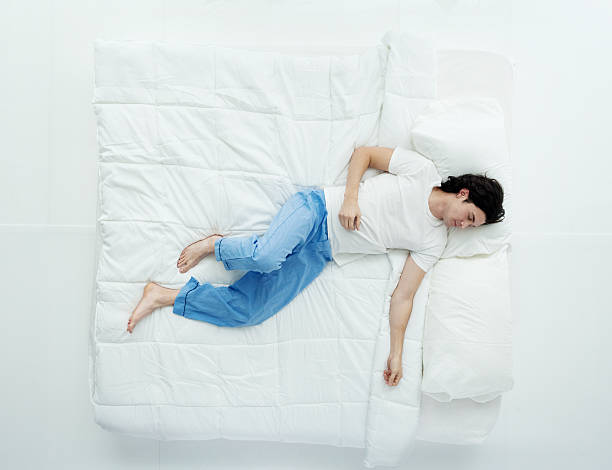 Top view of man sleeping on bed Top view of man sleeping on bedhttp://www.twodozendesign.info/i/1.png man sleeping top view stock pictures, royalty-free photos & images