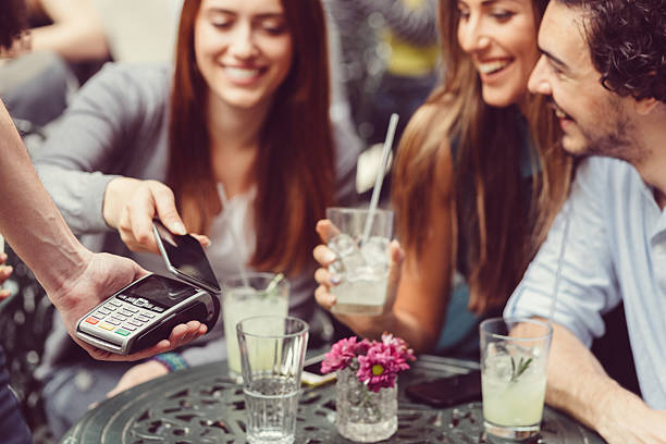 istock Friends making contactless payment with smartphone 527056166