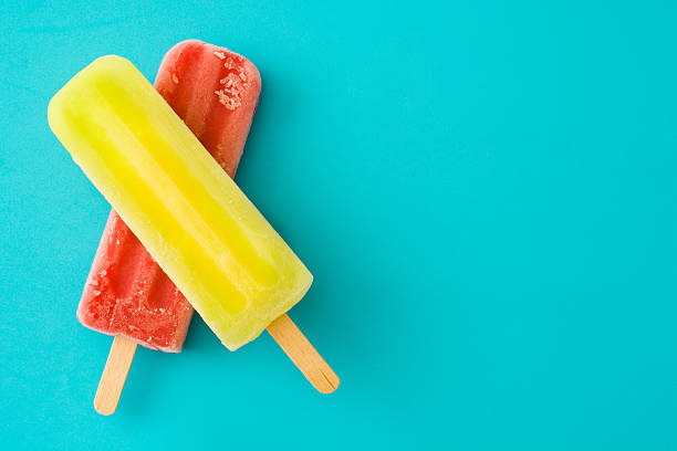 Popsicles Strawberry and lemon popsicles on blue background flavored ice photos stock pictures, royalty-free photos & images