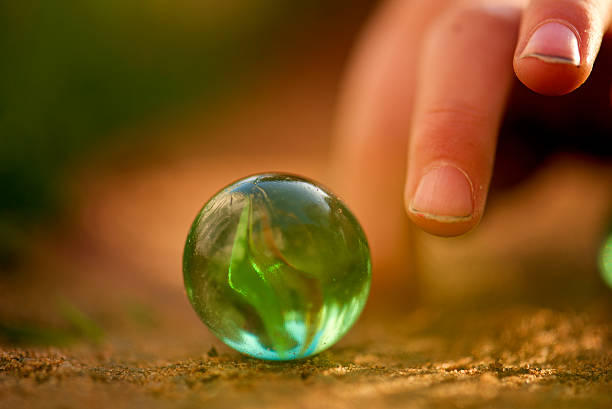istock glass marble and kid fingers ,macro 527069869