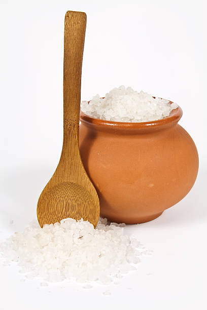 Sea salt crystals Sea salt crystals in clay pot with a wooden spoon sodium intake stock pictures, royalty-free photos & images