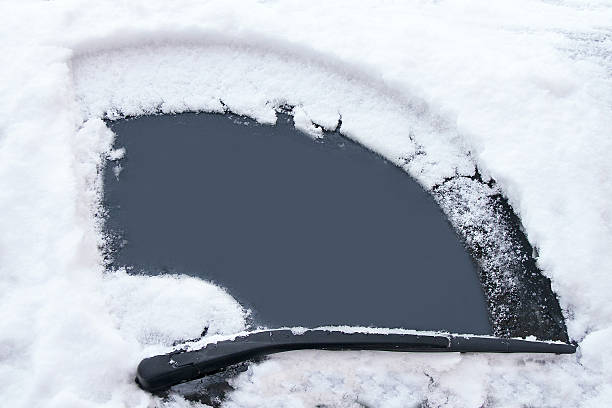 Car's window has been cleaned from snow by wipers. Transportation, winter, weather, vehicle concept. Car's window has been cleaned from snow by wipers in the winter day. Empty window for your message. Image has copy space for text. Close up. windshield wiper snow stock pictures, royalty-free photos & images