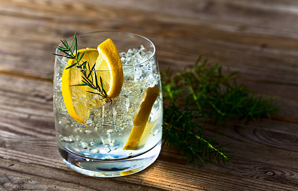 Gin with lemon and ice alcoholic drink with lemon and ice on a old wooden table tonic water stock pictures, royalty-free photos & images