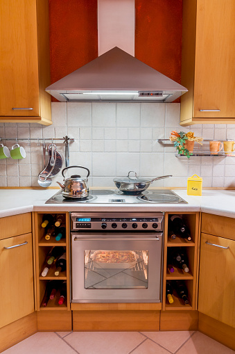 Diagonal view of a modern cooking area with stove, oven and chimney