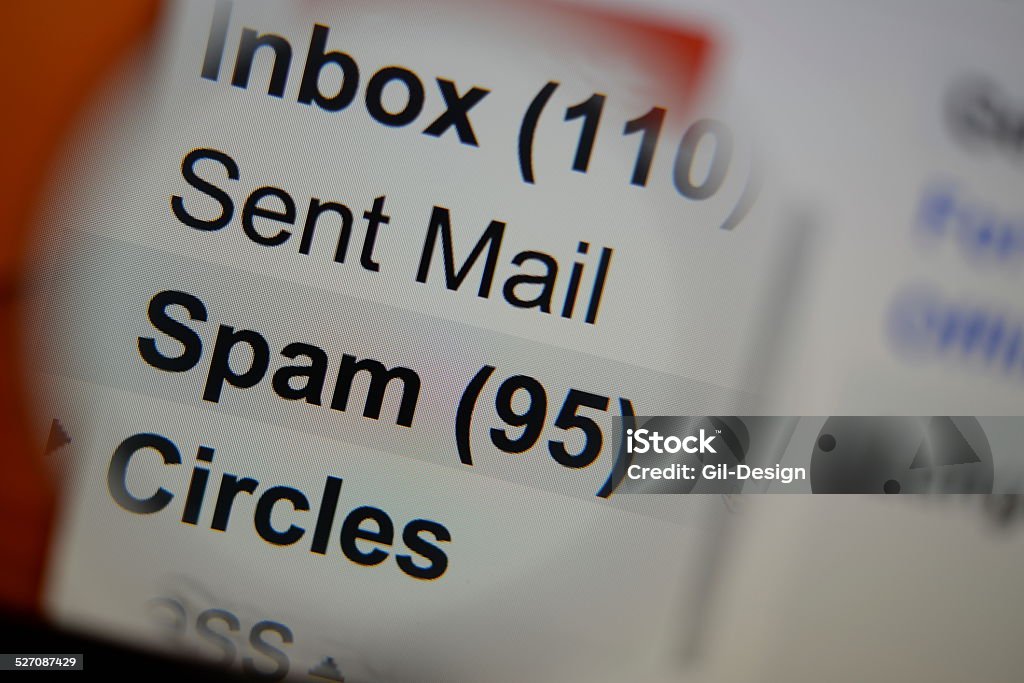 Magnifying glass showing a spam folder. Magnifying glass showing a spam folder in the mailbox on the monitor screen. E-Mail Stock Photo