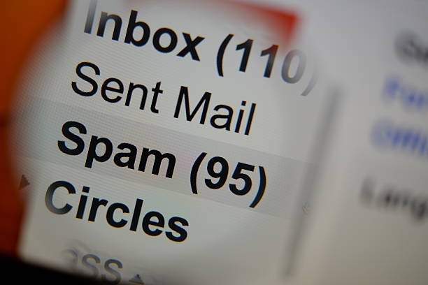 Magnifying glass showing a spam folder. Magnifying glass showing a spam folder in the mailbox on the monitor screen. e mail spam stock pictures, royalty-free photos & images
