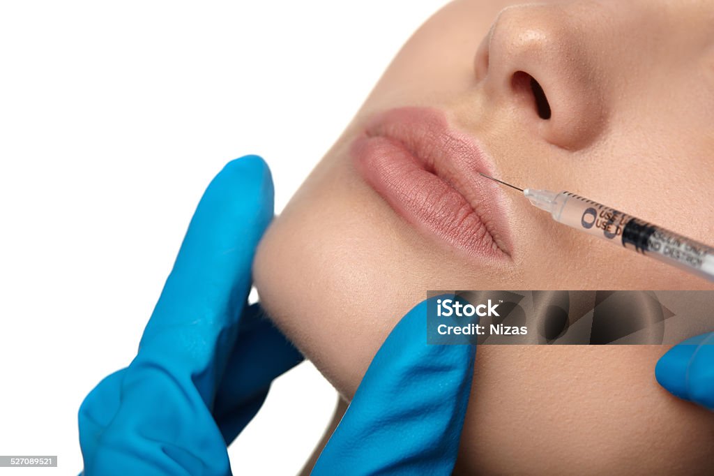 Beauty woman botox injections. Portrait of young woman getting cosmetic injection of botox, isolated over white background. Adult Stock Photo