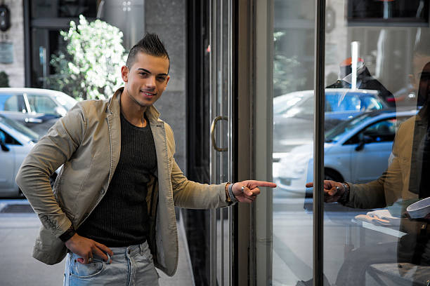 istock Attractive young man pointing finger at shop window 527089791