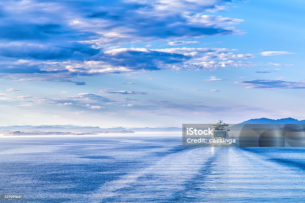 Path on the water from a large cruise ship The white liner sailing on blue water Cruise Ship Stock Photo