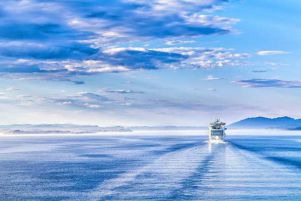 Path on the water from a large cruise ship The white liner sailing on blue water fjord photos stock pictures, royalty-free photos & images