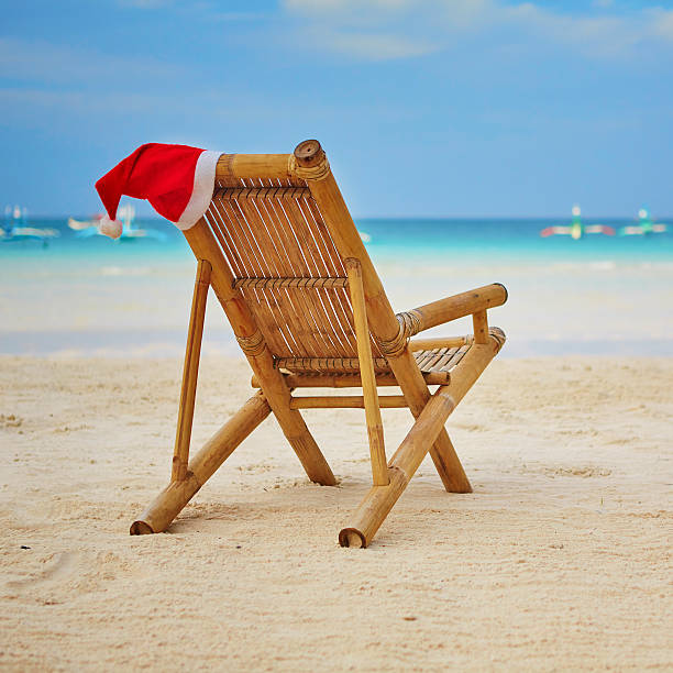 istock Santa hat on chaise longue on white sand beach 527092941