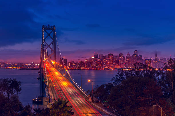 skyline di san francisco bay bridge all'alba e - san francisco county embarcadero center bay bridge built structure foto e immagini stock