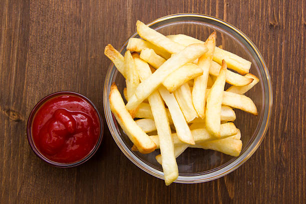 istock Bowl of chips and ketchup on wood from above 527094145