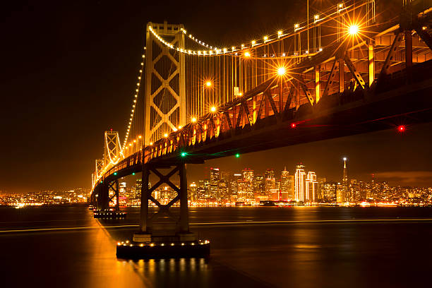 san francisco-skyline und bay-brücke bei nacht - san francisco county embarcadero center bay bridge built structure stock-fotos und bilder