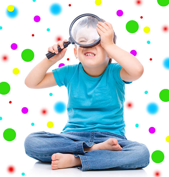istock Cute little boy is playing with magnifier 527112497