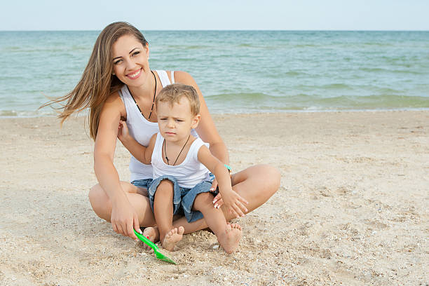 istock Mother and her son having fun on the beach 527114389