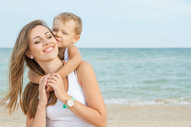 istock Mother and her son having fun on the beach 527114391