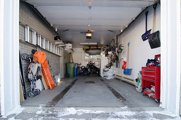 The interior of a car residential garage with no car where we see all the stuff that can be found in a garage, with snow tire traces.