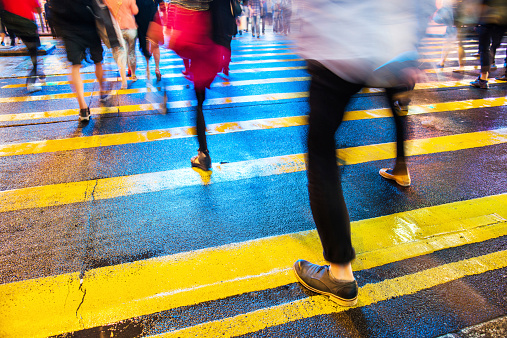 Low section of people crossing street in hong kong, motion blur.