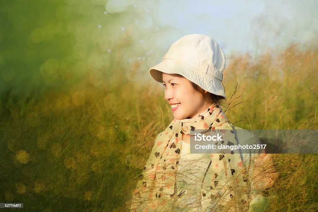 Young woman is standing in meadow Young woman is standing in meadow with raised arms enjoying sunlight Agricultural Field Stock Photo