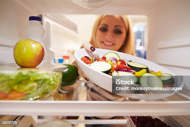 Woman Looking Inside Fridge Full Of Food And Choosing Salad Stock Photo - Download Image Now