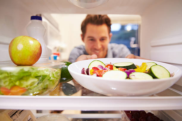 istock Man Looking Inside Fridge Full Of Food And Choosing Salad 527117821