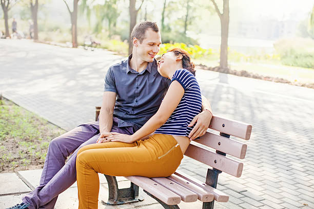 istock mixed-race couple sitting on a bench in a park 527119071