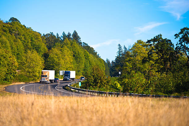 istock Two powerful semi trucks on winding highway 527119169
