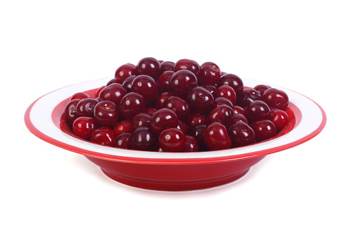 Red cherries in a striped plate isolated on a white background