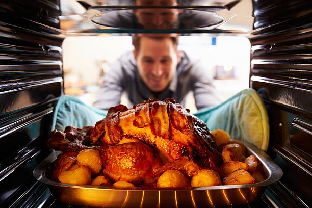 uomo prendendo tacchino arrosto fuori dal forno - christmas food dinner turkey foto e immagini stock