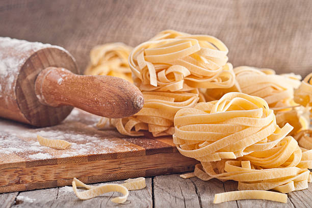 tagliatelles maison. raw de pâtes sur la table en bois - pasta noodles tagliatelle freshness photos et images de collection
