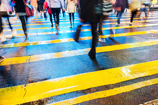 Low section of people crossing street in hong kong, motion blur.