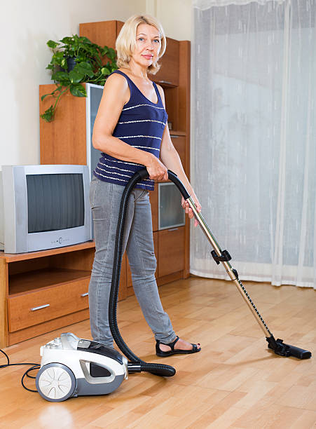 istock woman cleaning with vacuum cleaner 527137353