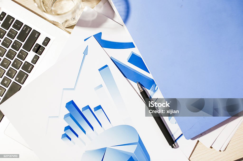 Laptop and chart on desk Business Stock Photo