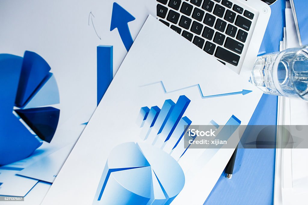 Laptop and chart on desk Business Stock Photo