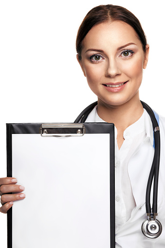 Cheerful young female doctor showing clipboard with copyspace for text or design and smiling, isolated over white background