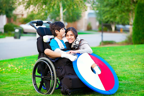istock Disabled brother hugging older sister while sitting in wheelchair 527139377