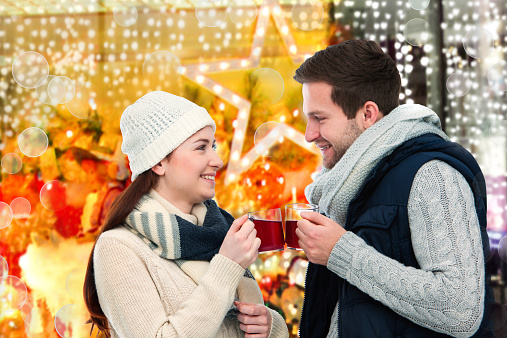 Romantic young couple drinking hot wine punch claret on christmas market
